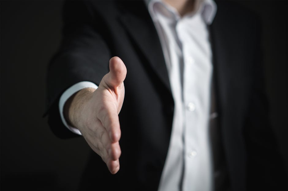 pexels-photo-327540-327540 Close-up of a businessman extending hand for a handshake, symbolizing agreement and partnership.